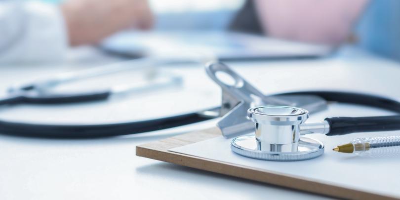 Close-up of a stethoscope resting on a clipboard, representing healthcare, medical care, or a clinical setting.