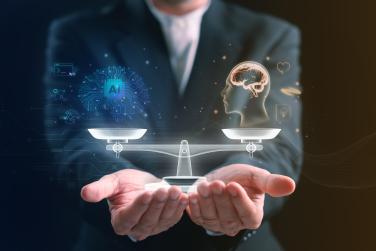 Businessman holding a balanced scale between artificial intelligence and human mind