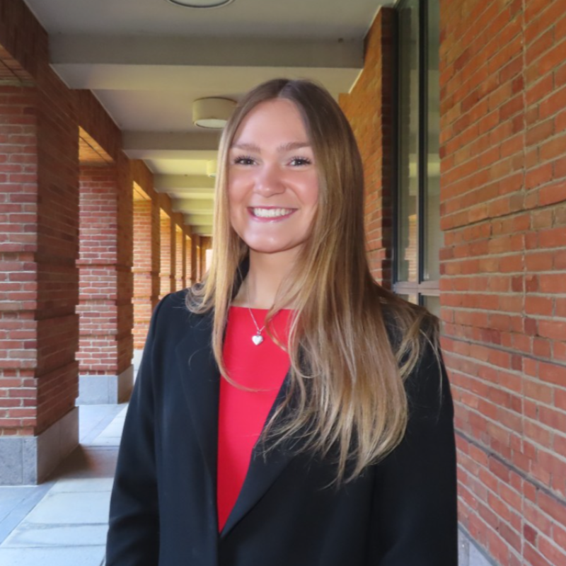 Jenna smiling and wearing a suit, in front of Gerlach Hall