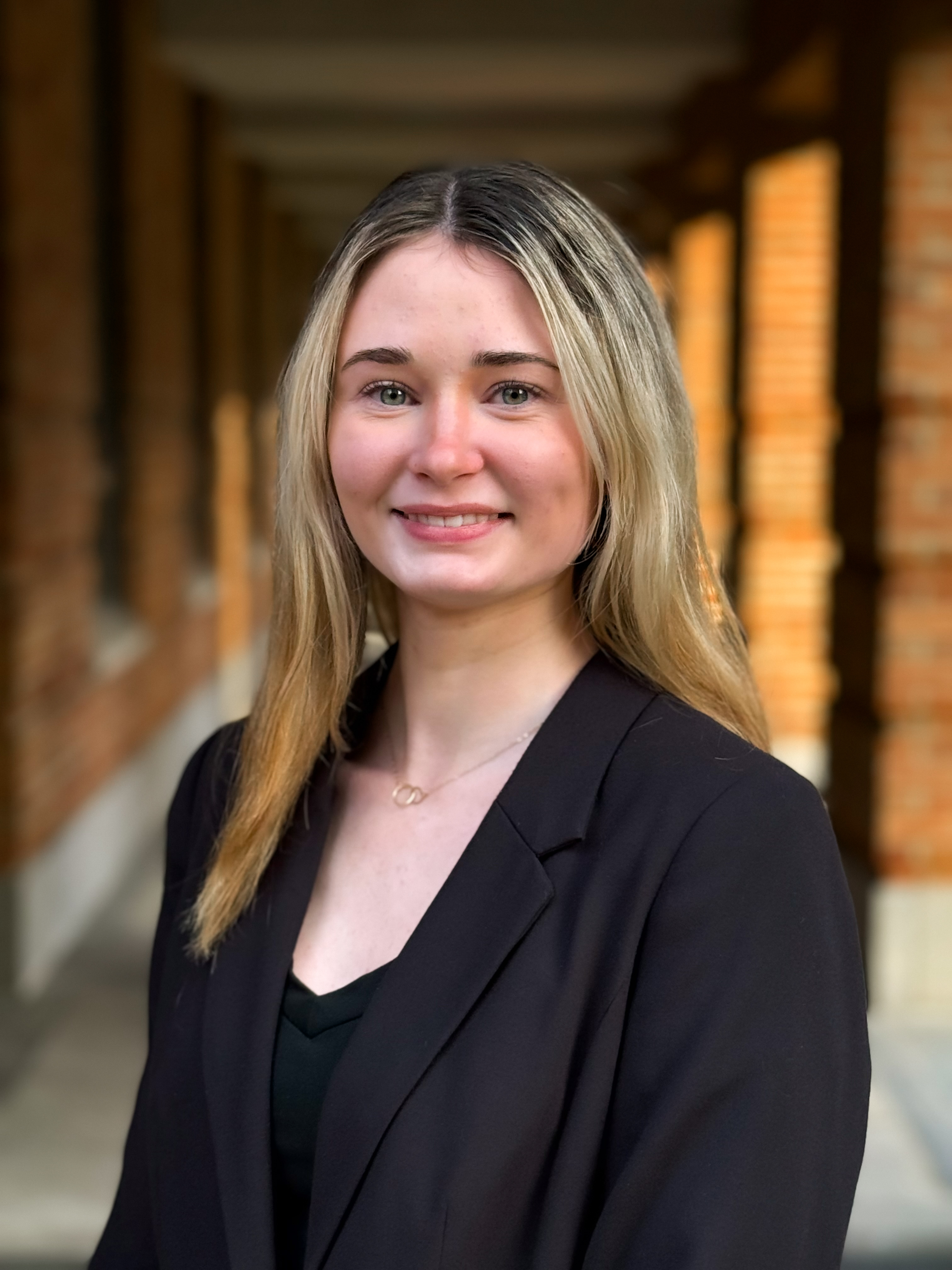 woman smiling at the camera with a black suit jacket.