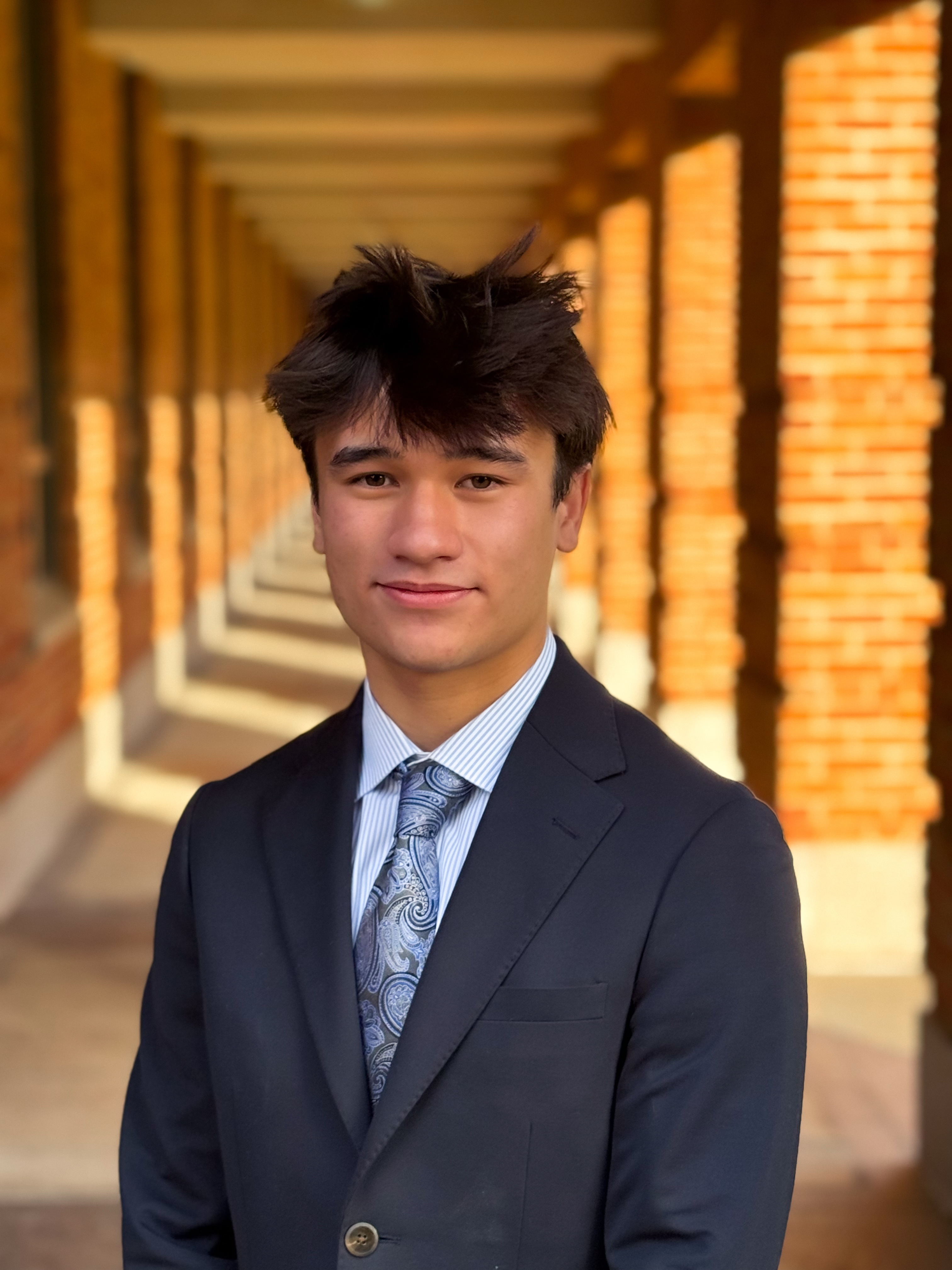 man looking at the camera with dark blue tux and light blue tie