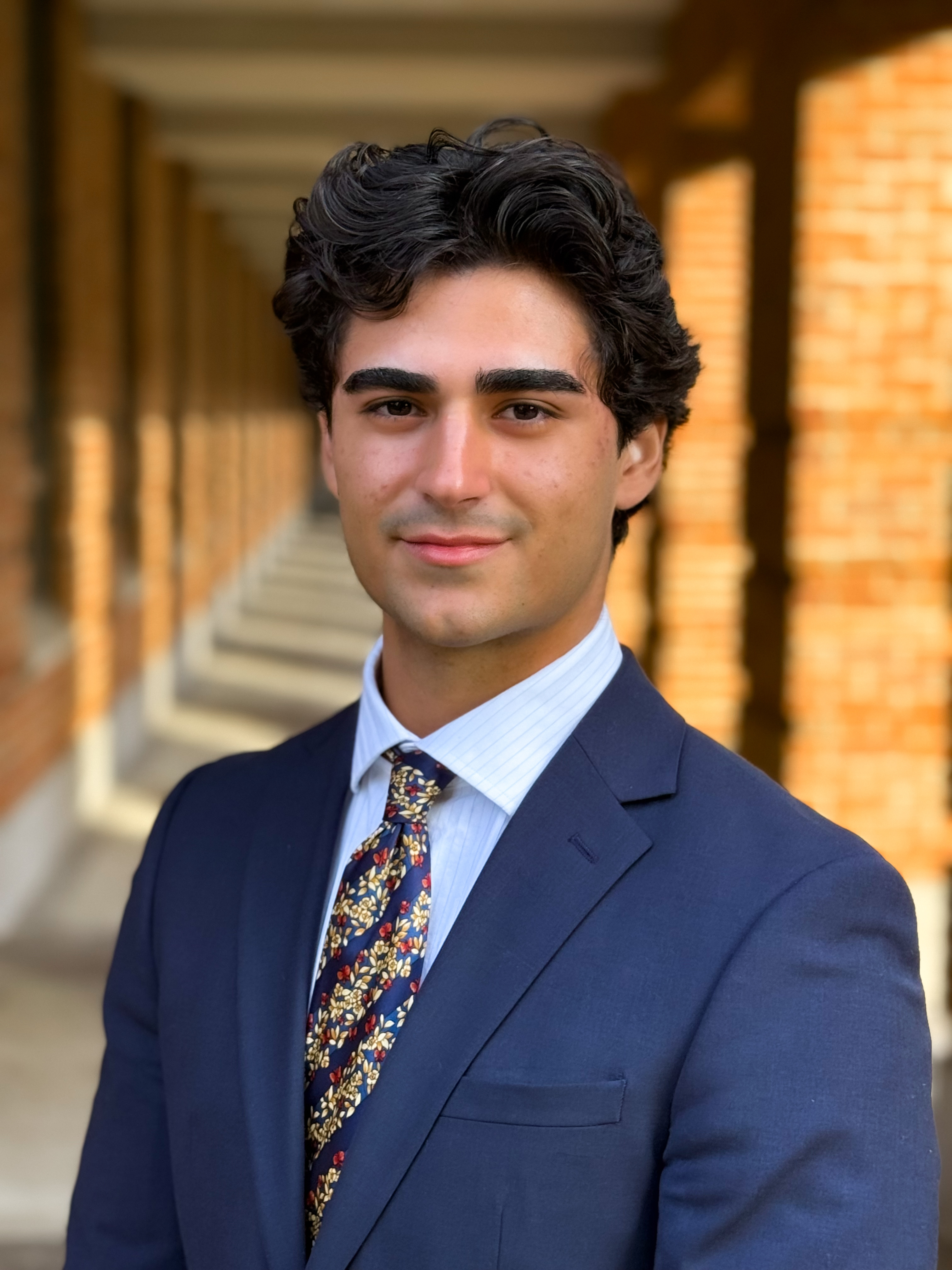 man smiling at camera with navy blue tux