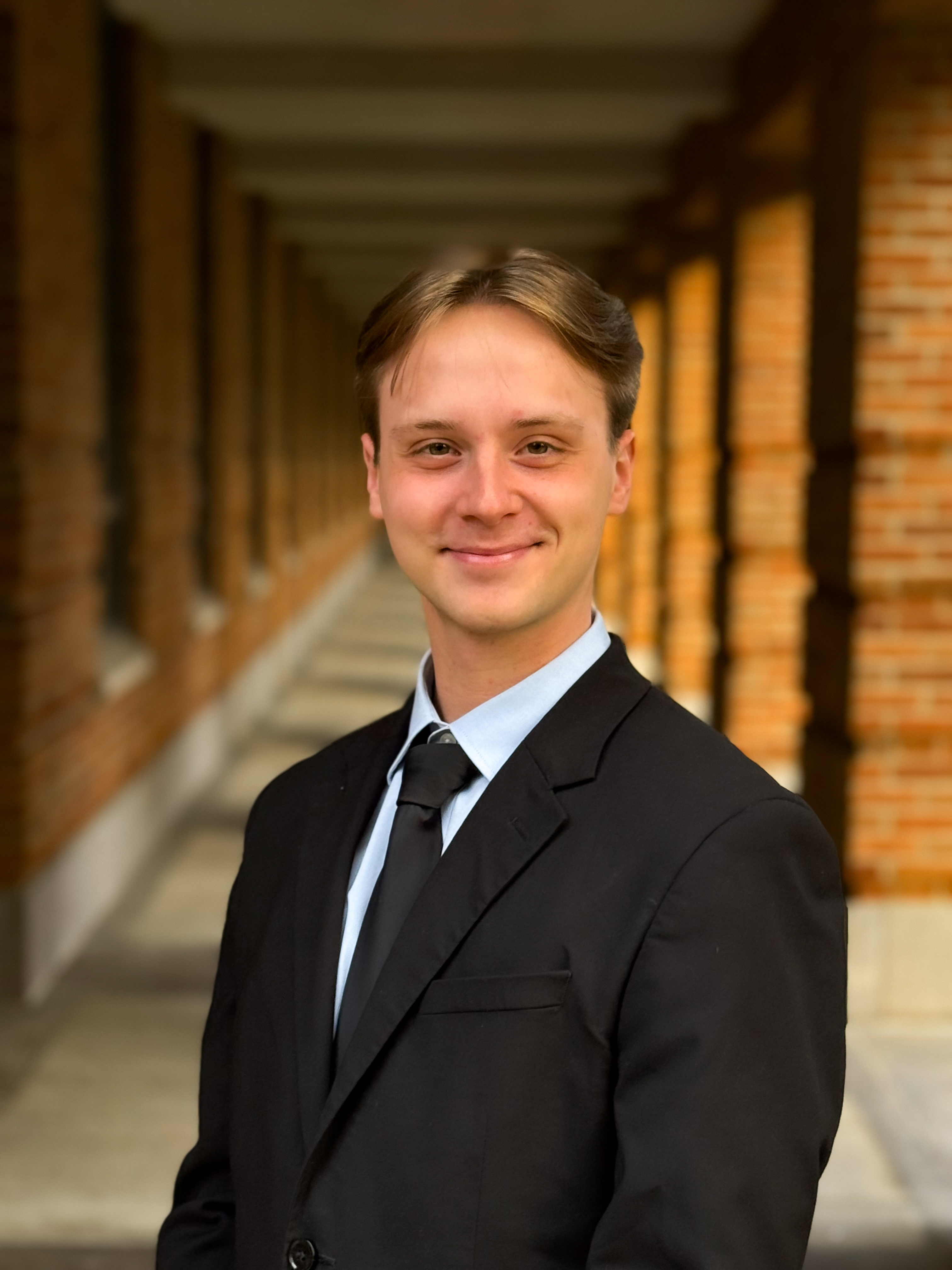 man smiling at the camera with a black tux and a black tie