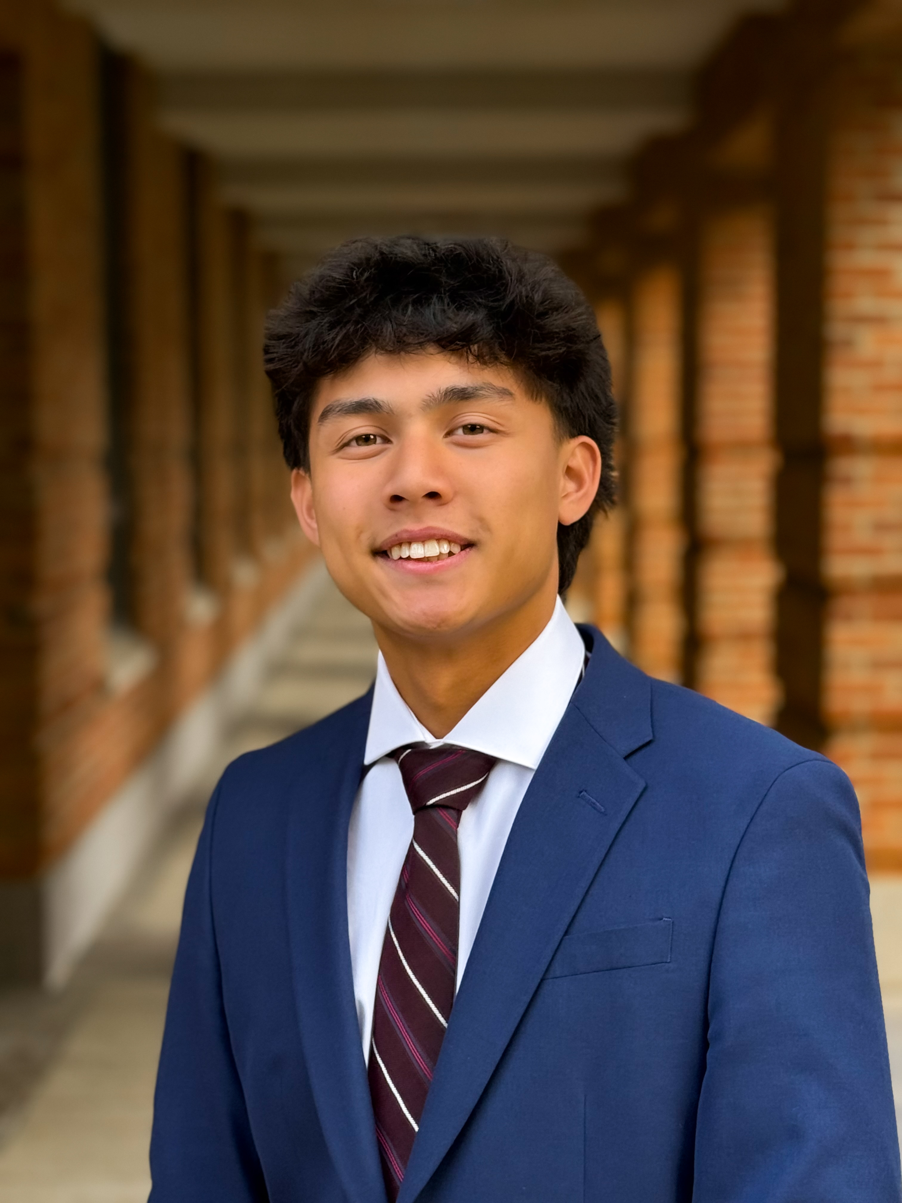 man smiling at the camera with blue tux and burgundy tie