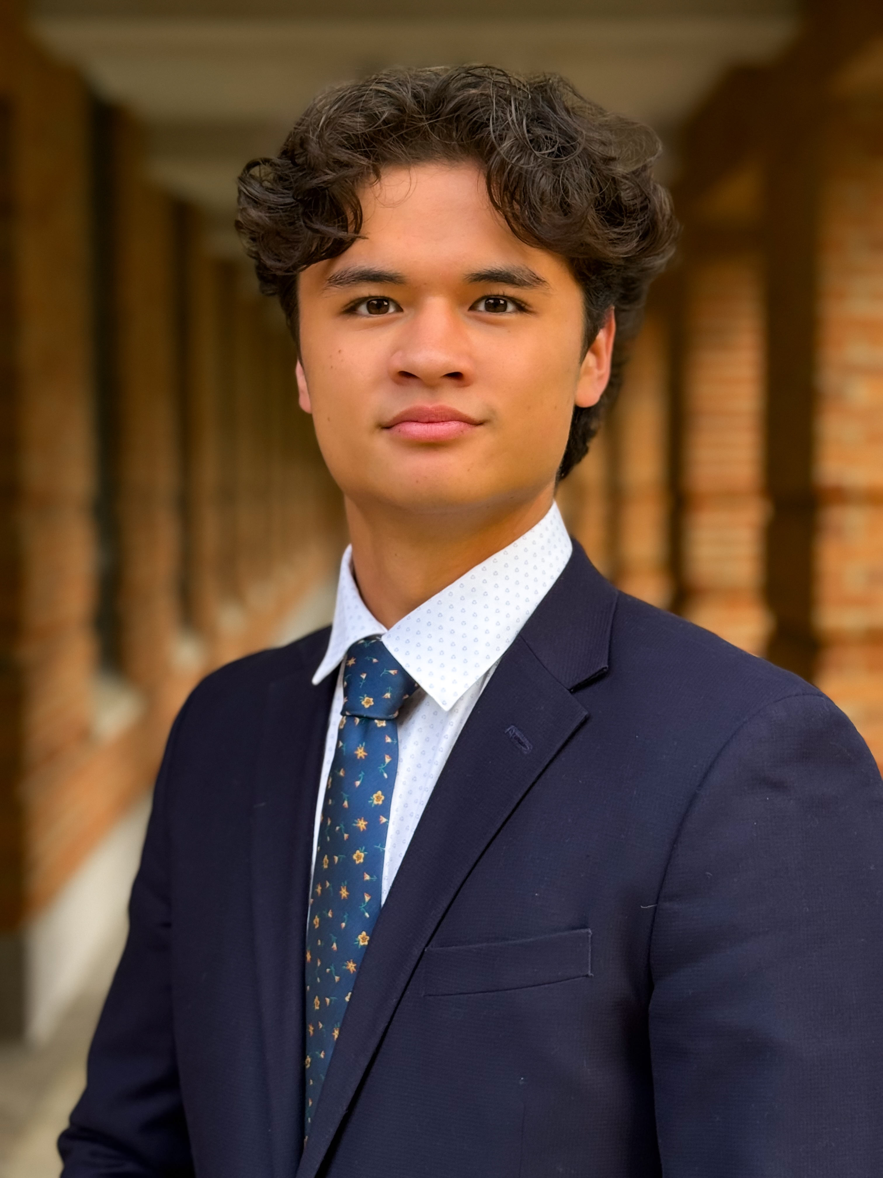 man looking at the camera with navy blue suit and blue tie