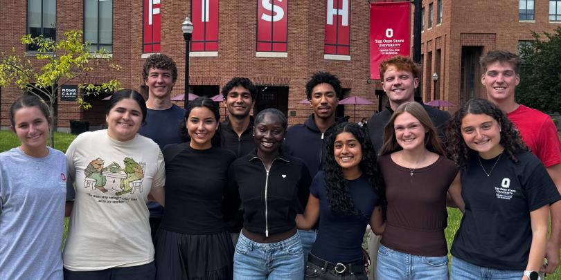 Group of 12 Ohio State student employees smiling and standing in front of Mason Hall