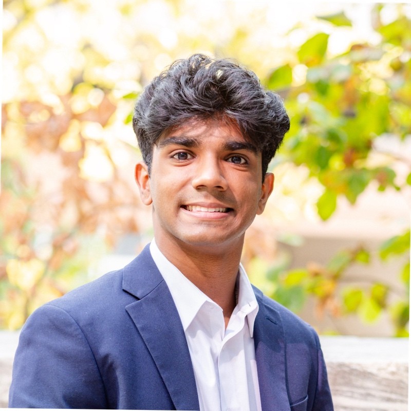 Hari wearing white shirt and blue jacket