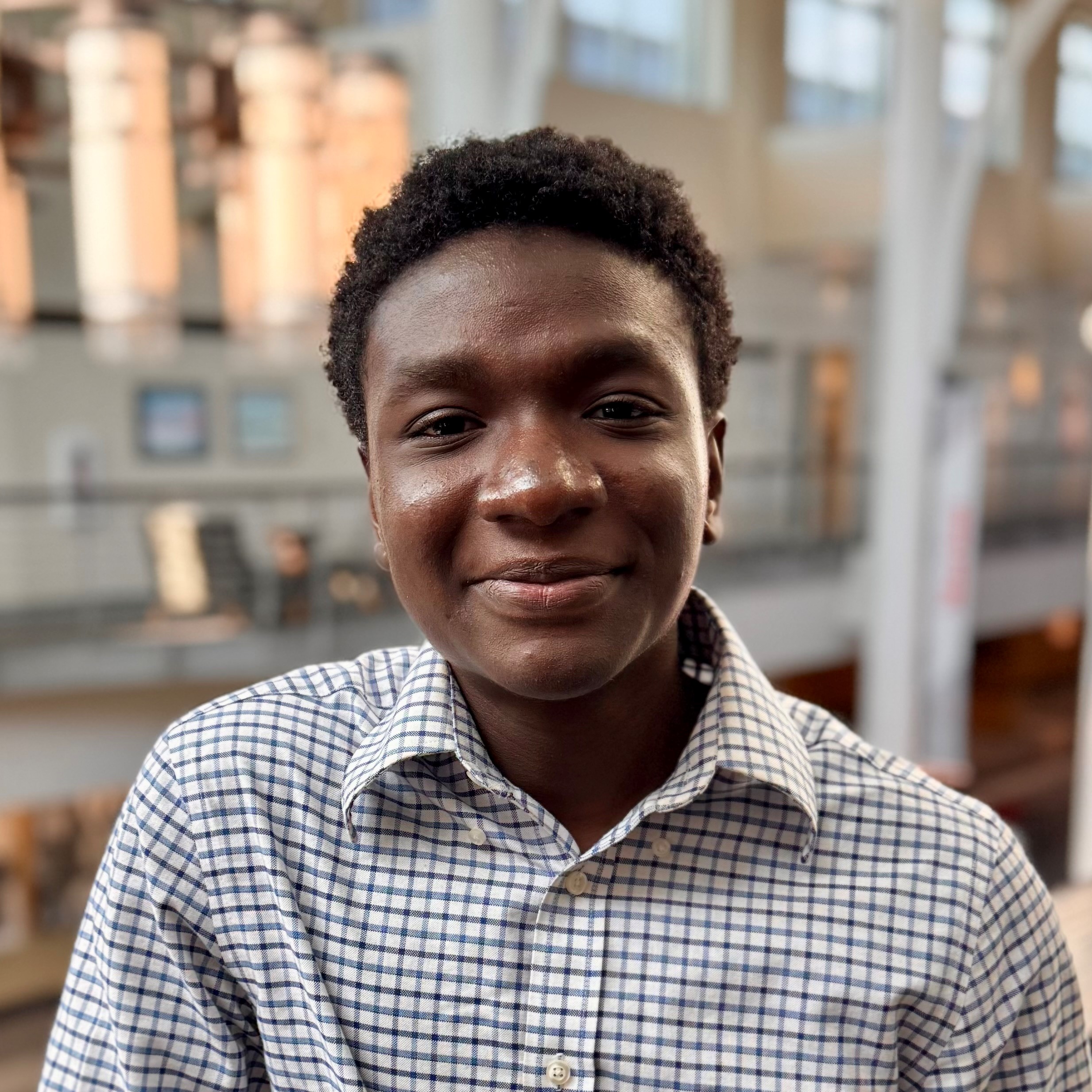 Kodjo wearing white and grey checkered shirt