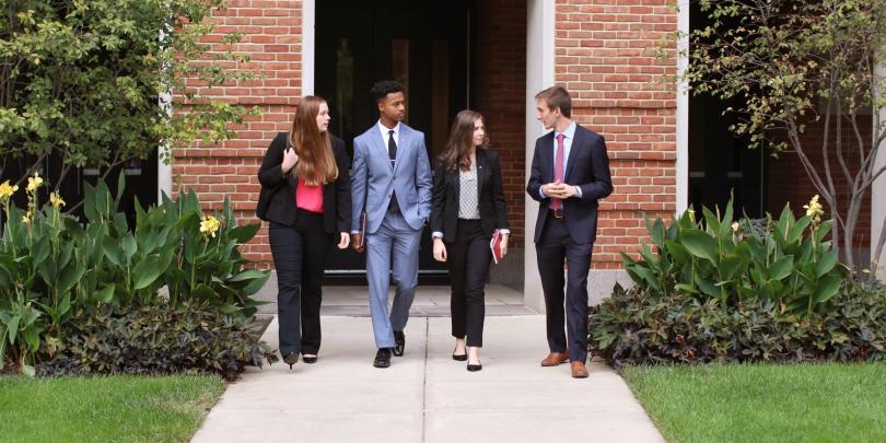 Students conversating as they walk on Fisher's campus