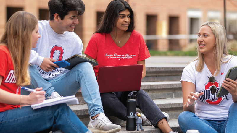 4 students sitting outside in the Fisher courtyard