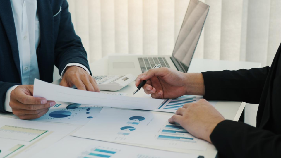 2 businesspeople discussing financial metrics