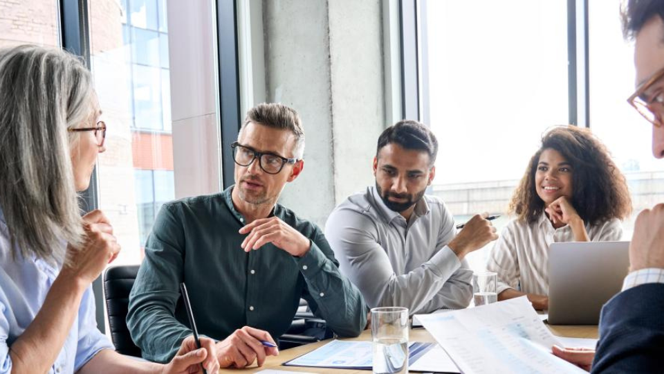 5 business leaders meeting in a conference room