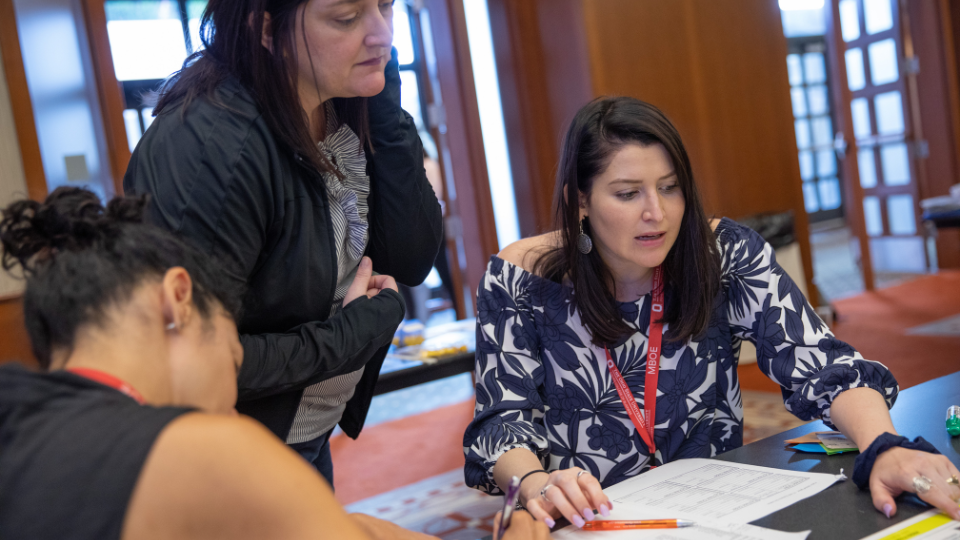 3 women at a table participating in a Lean Six Sigma activity