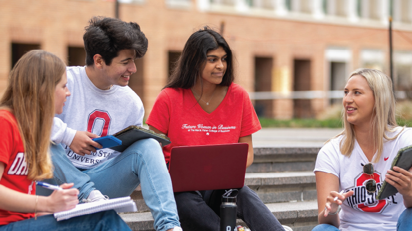 4 students sitting outside in the Fisher courtyard