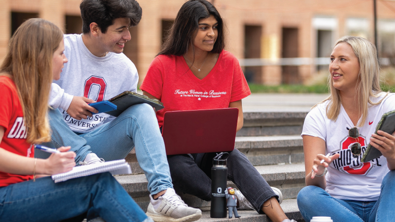 4 students sitting outside in the Fisher courtyard