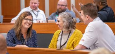 A team of three people talking in a classroom