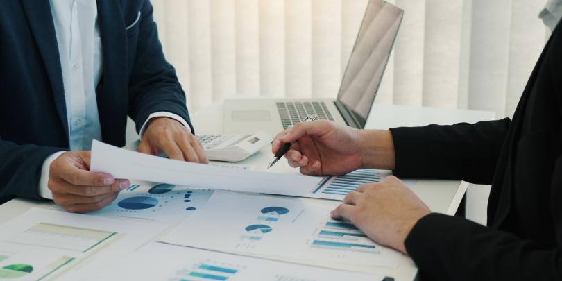 Two business professionals having a meeting discussing charts