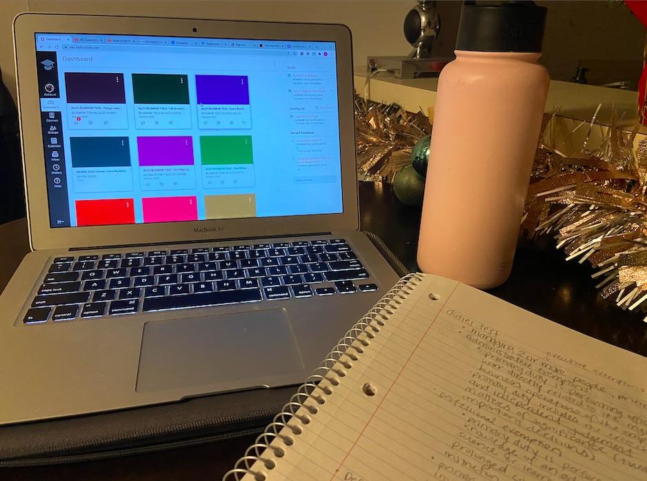 Photo of a laptop, notebook, and water bottle on a table