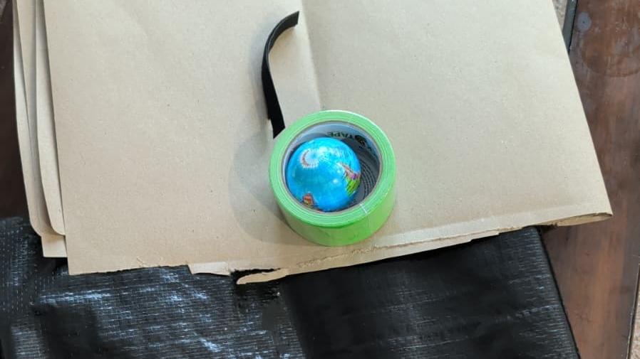 Items in the bag.   1. Small Globe  2. One strip of Velcro  3. Brown paper  4. Duct tape  5. Plastic Sheet 