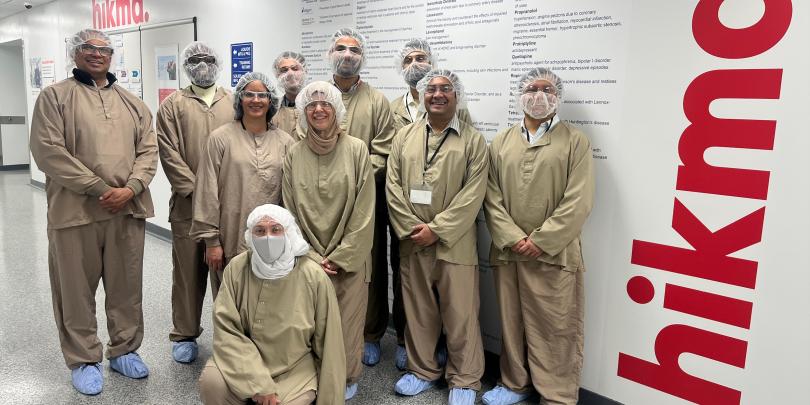 People fully clothed in special clothes in a pharmaceutical company
