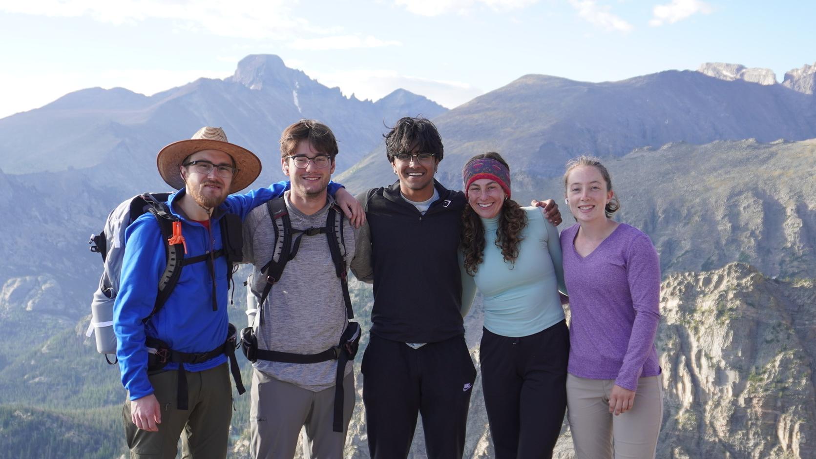 Students pose in front of a sweeping vista of mountians
