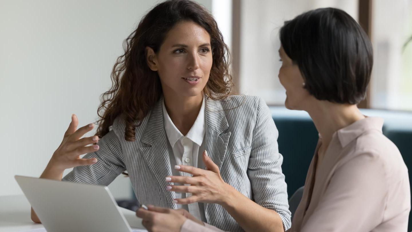 two female employees having a coaching conversation 