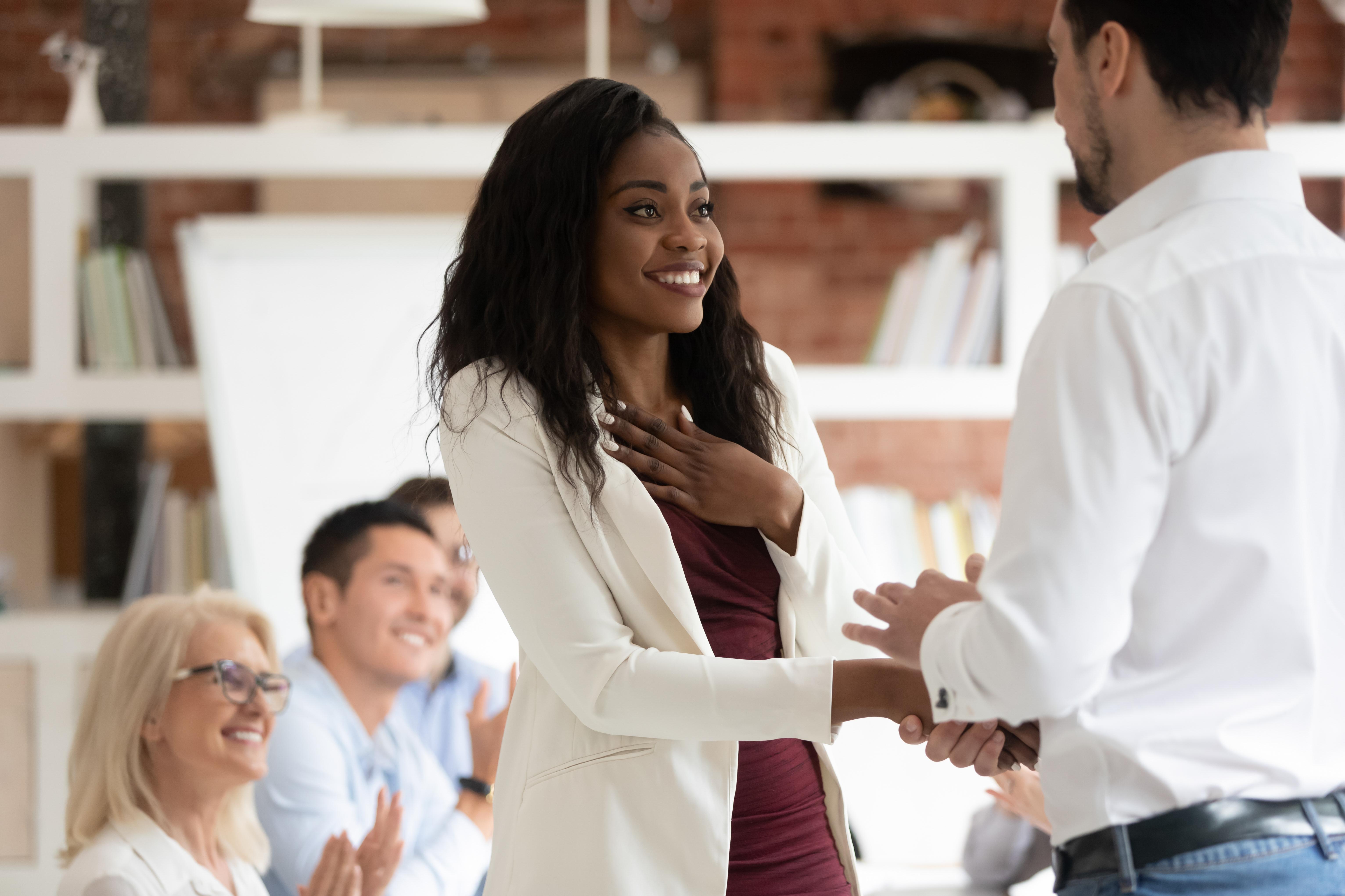 Woman getting handshake, looking happy