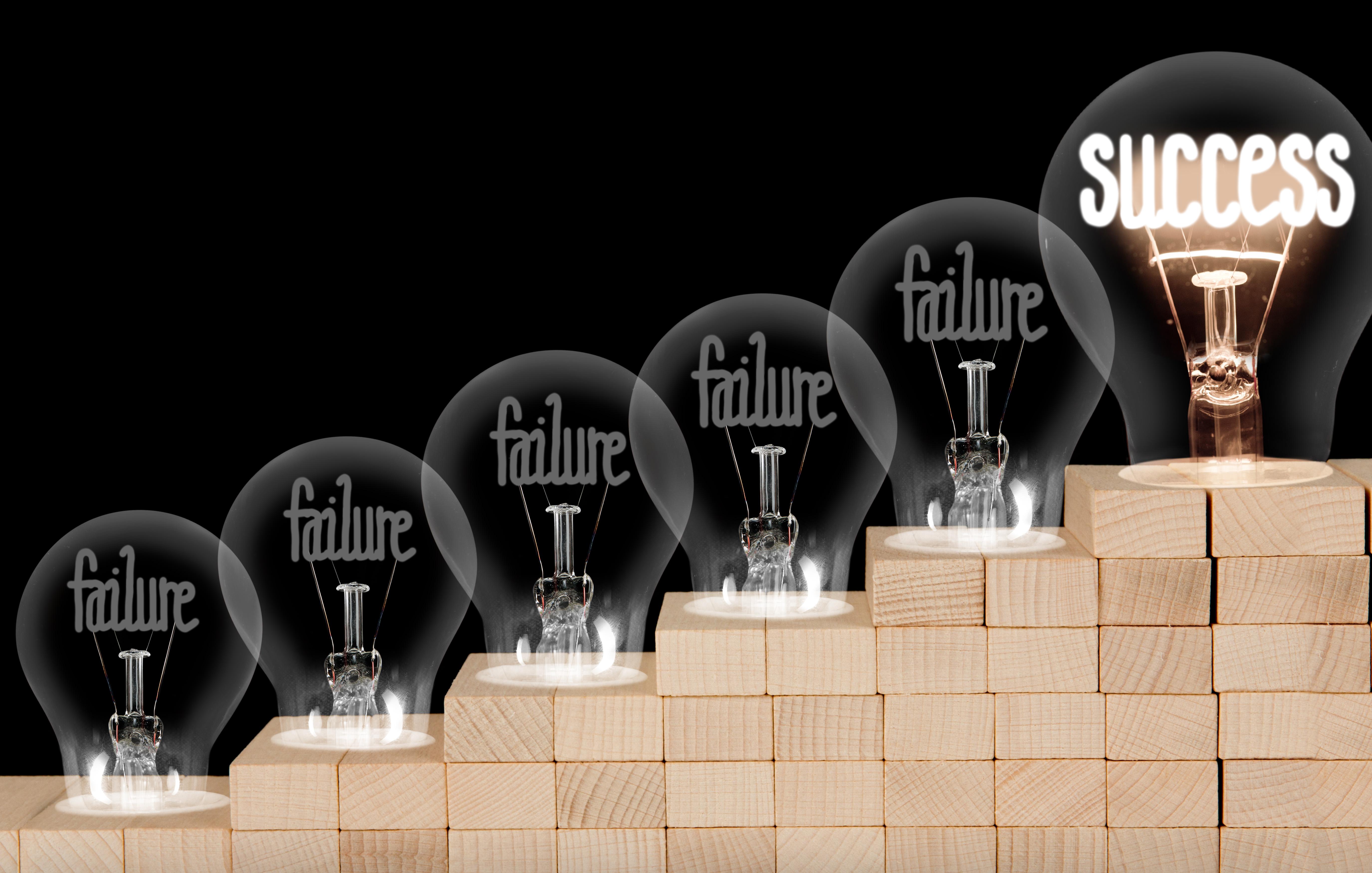 burned out light bulbs saying failure leading up to one saying success