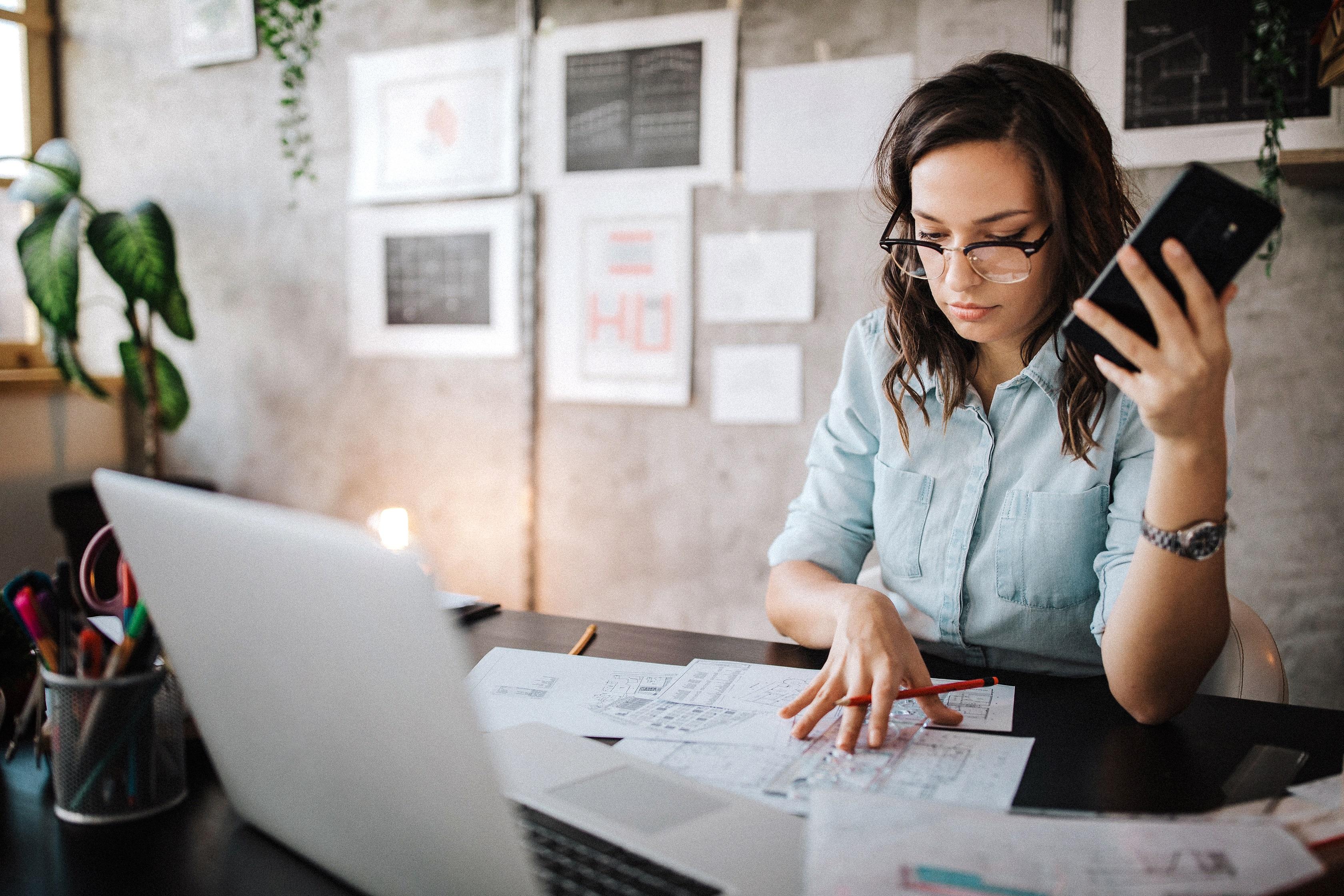 Woman at computer and looking at papers