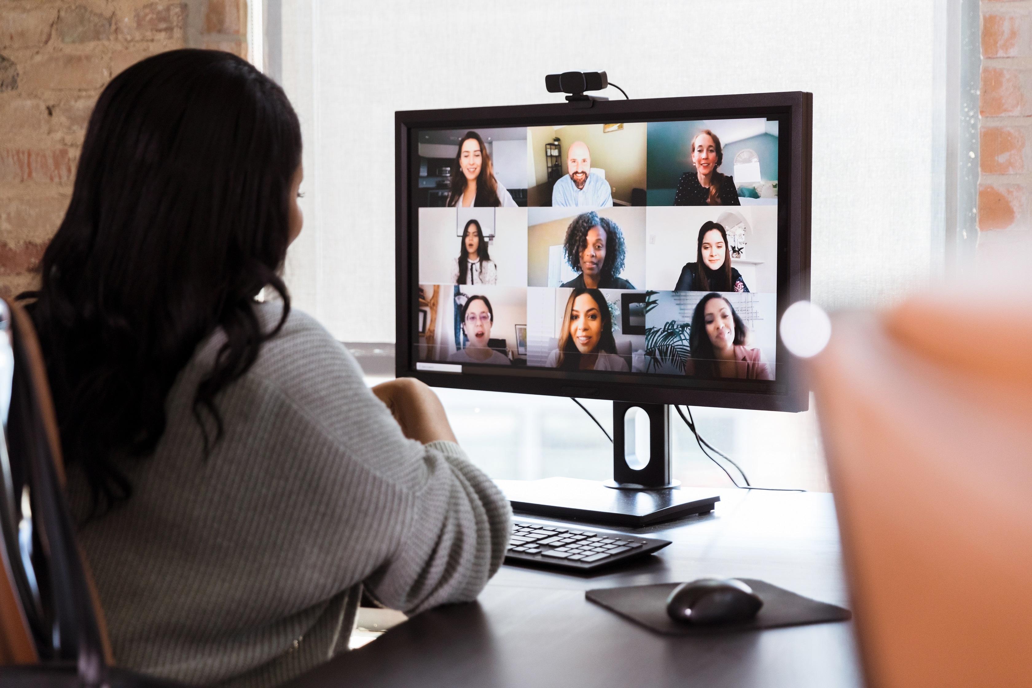 Woman looking at coworkers on computer screen