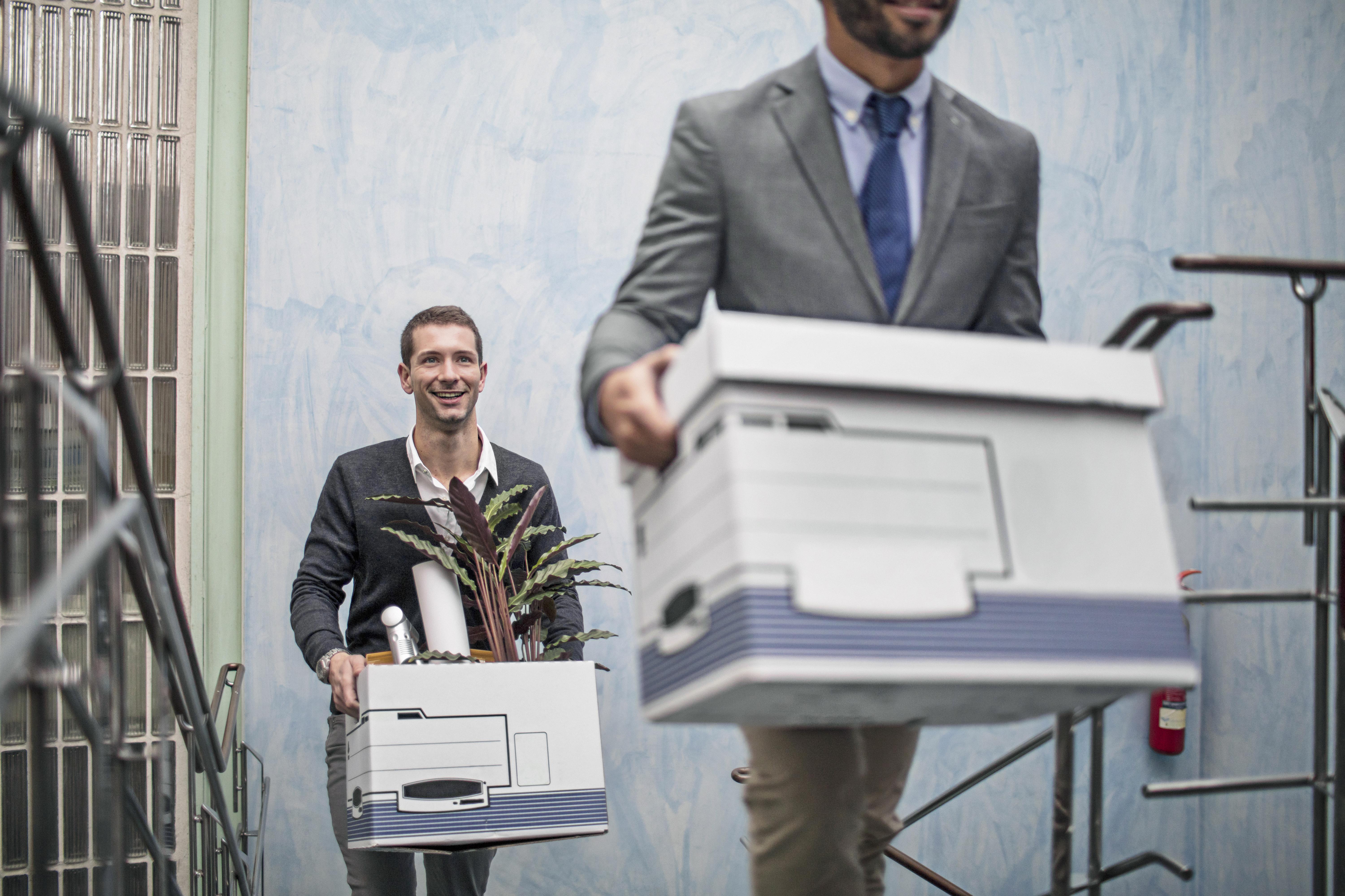 People carrying boxes out of an office