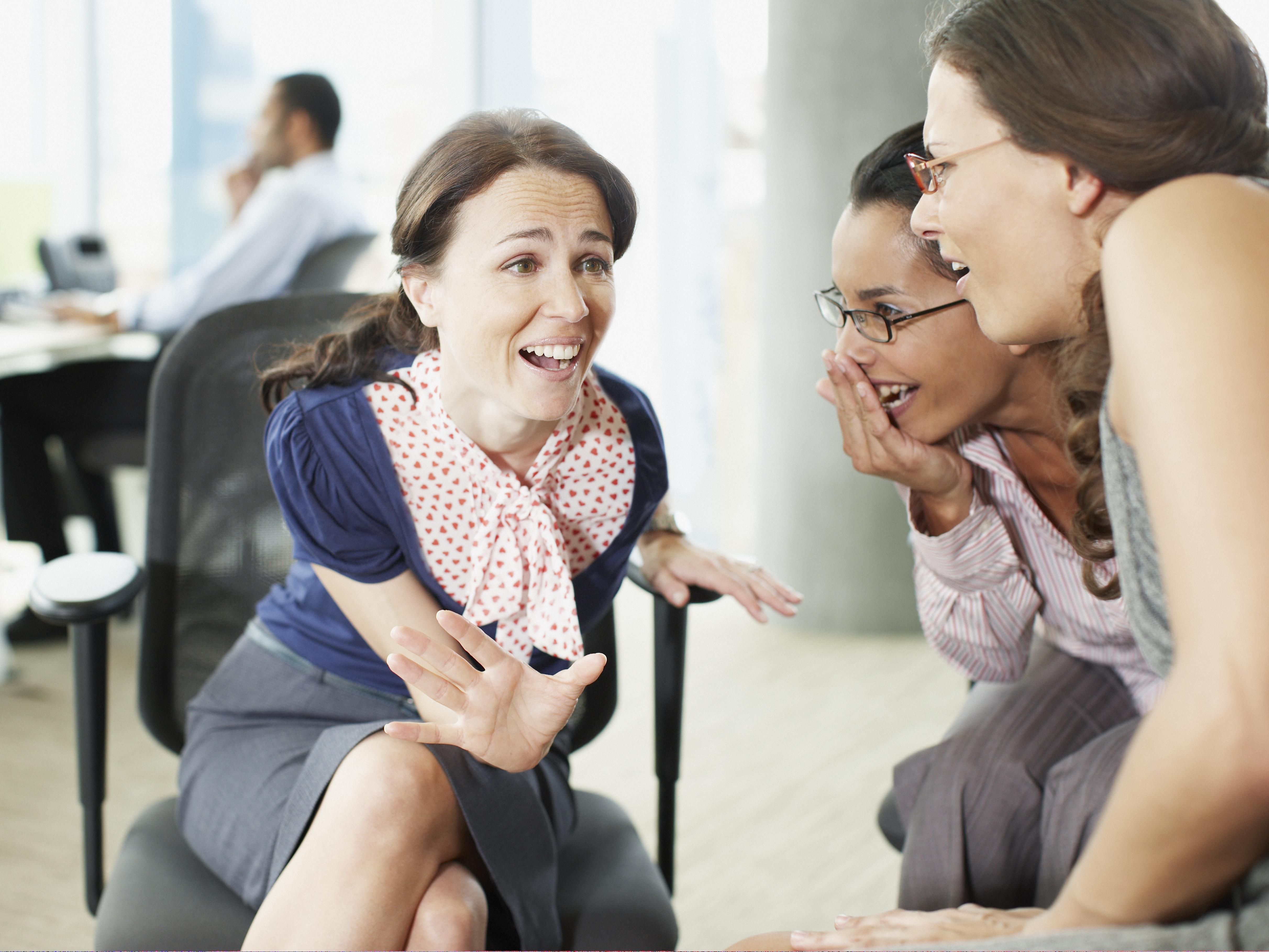 Several women gossiping in an office setting 