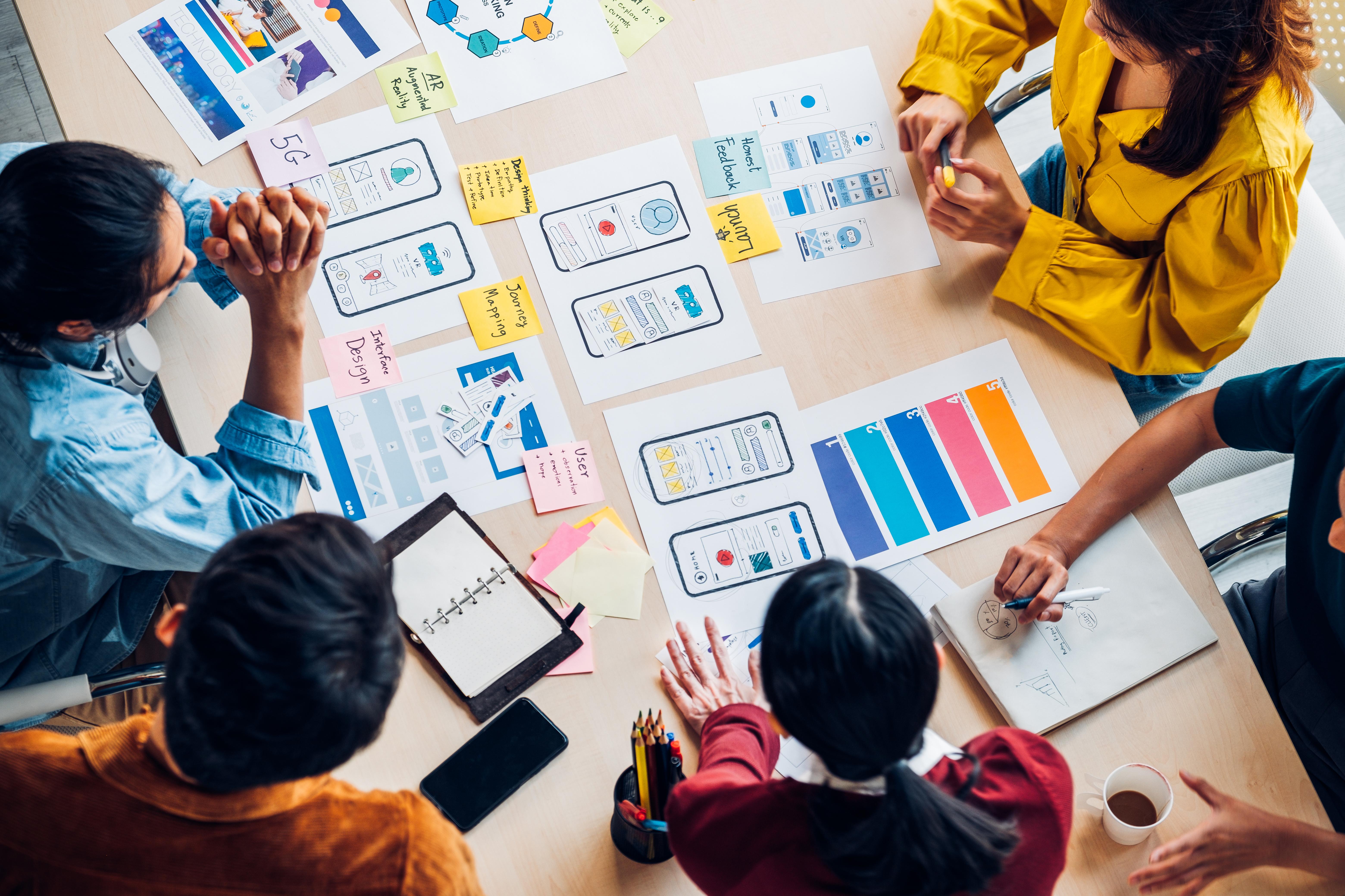 Overhead shot of people working at a table on a creative project 