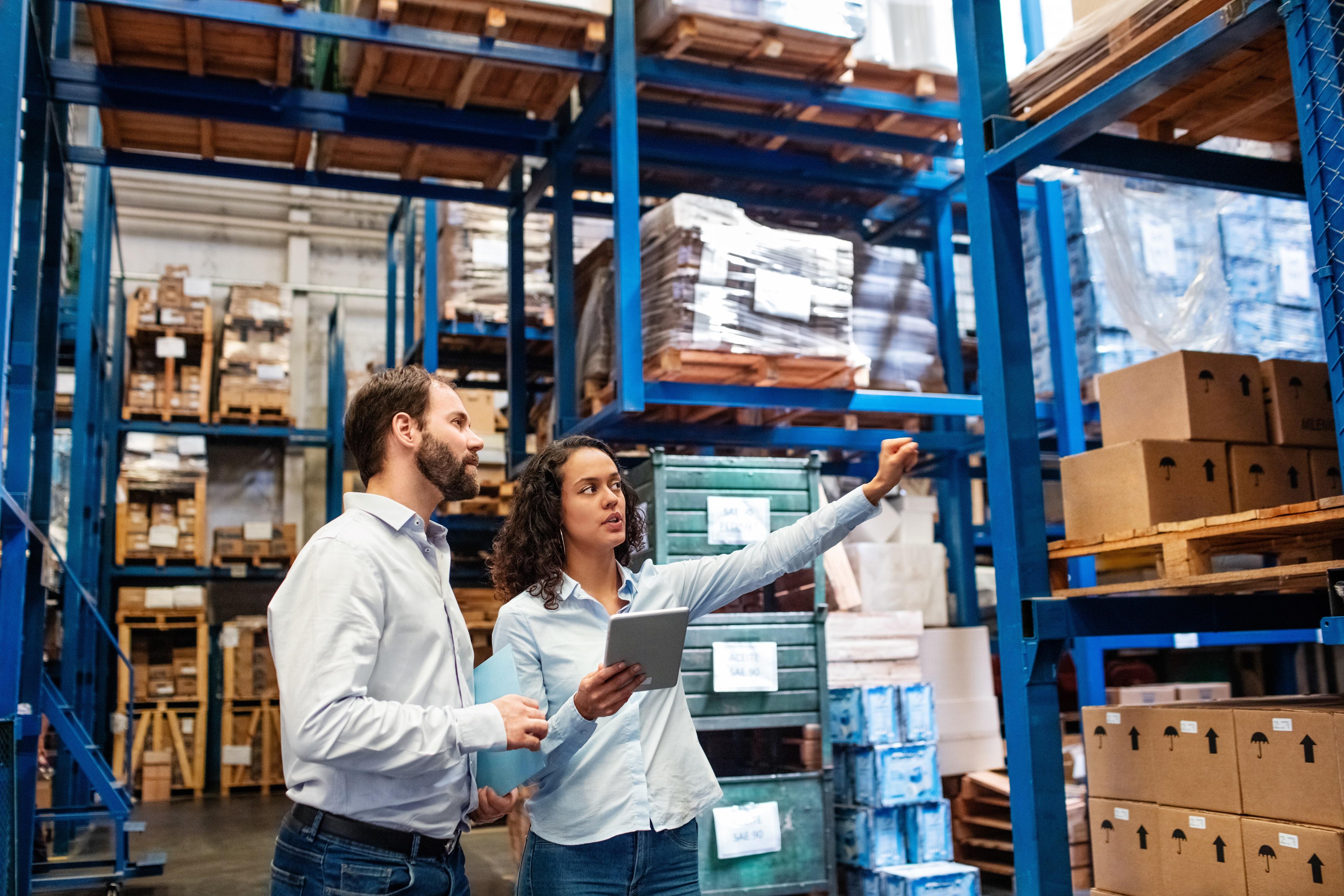 A man and a woman inspecting a warehouse