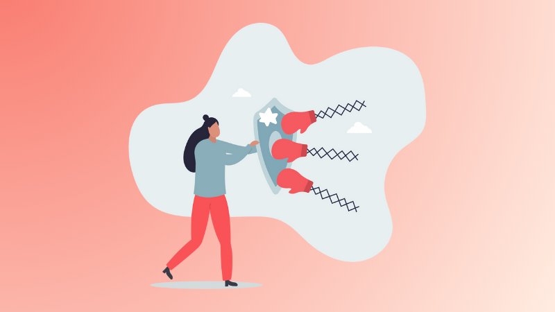 woman holding up shield blocking boxing gloves to symbolize resilience