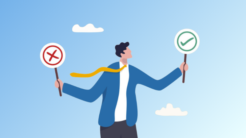 man holding one sign with an X and another sign with a checkmark