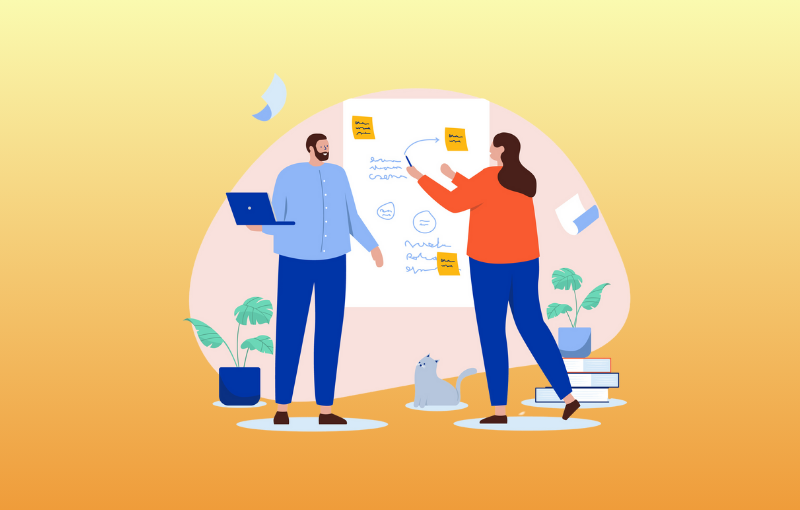 2 employees writing ideas on a board