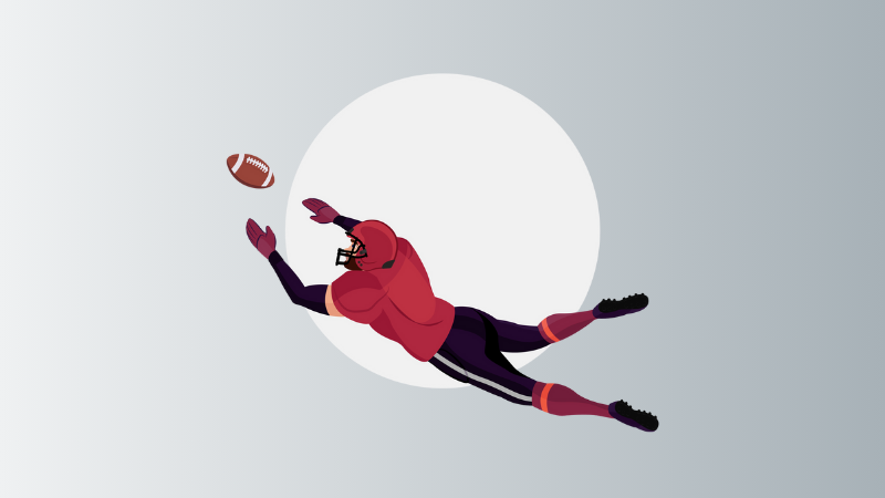 american football player diving to catch ball