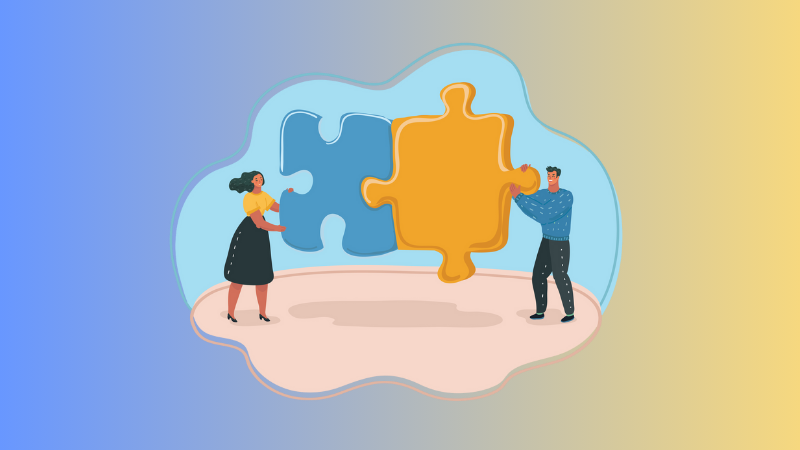 man and woman holding 2 puzzle pieces together tp show teamwork