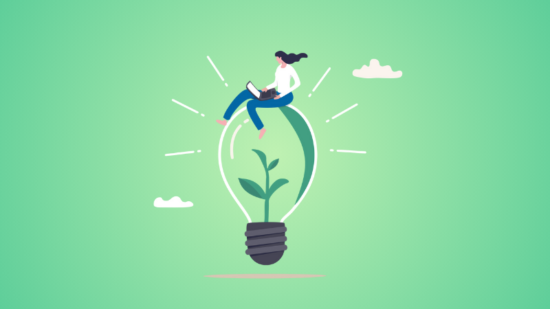 woman sitting on lightbulb using laptop