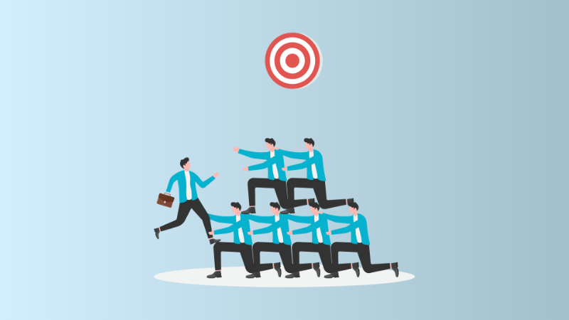 employees helping each other climb to reach a target