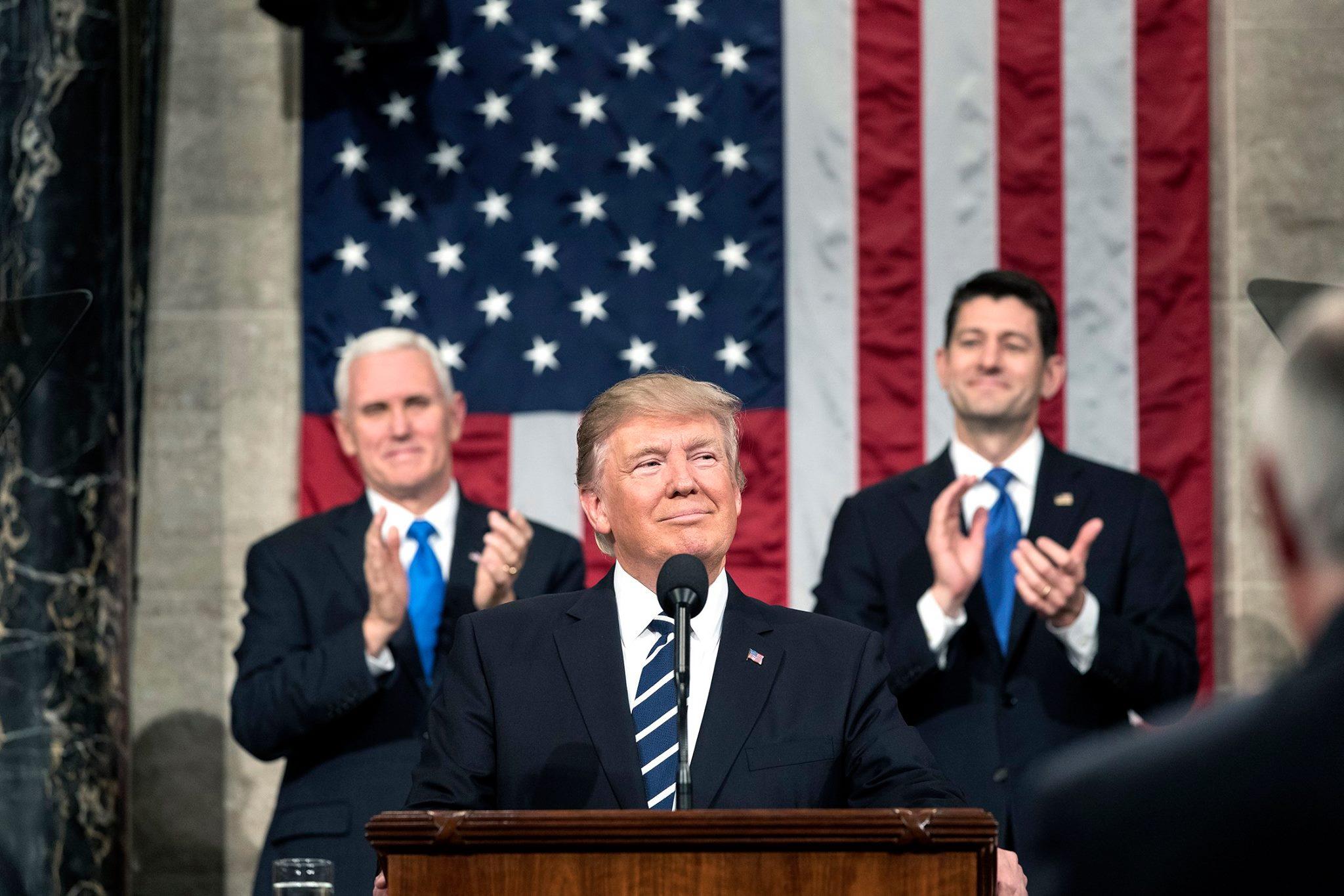 Donald Trump addressing House of Representation with Paul Ryan and Mike Pence standing behind