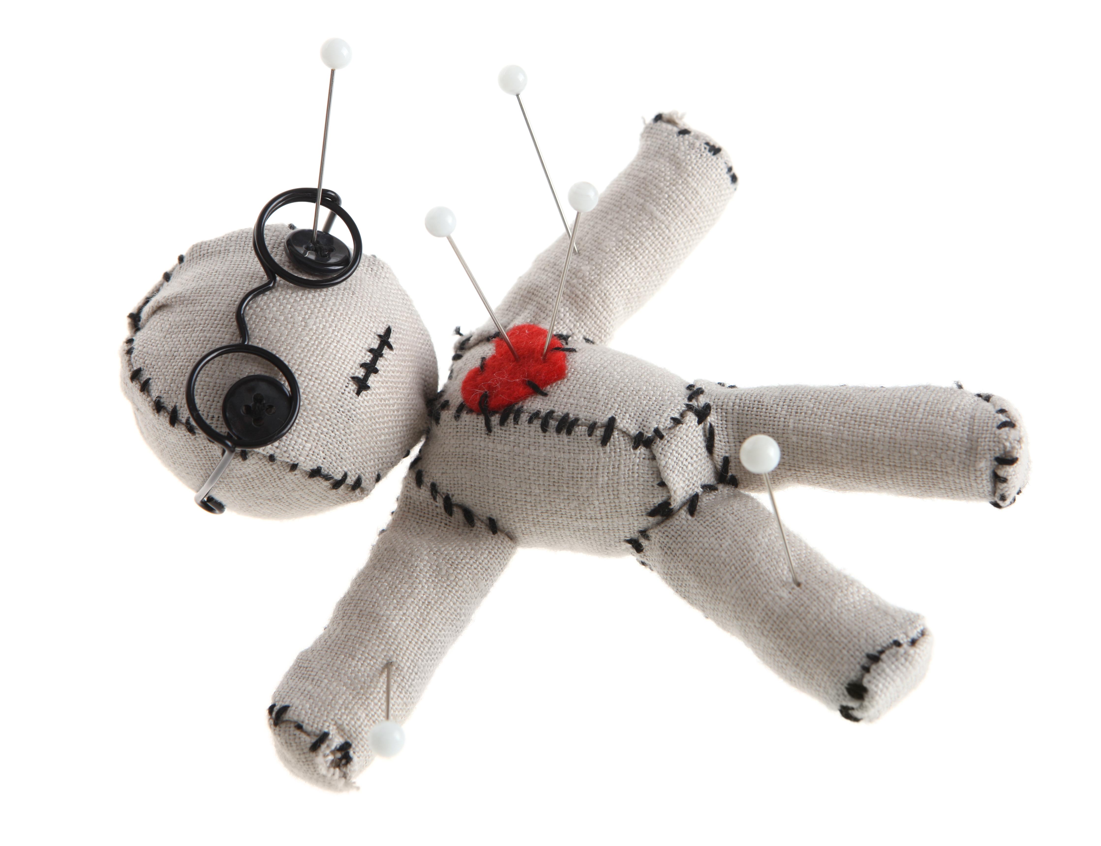 voodoo doll with several sewing pins stabbed into it