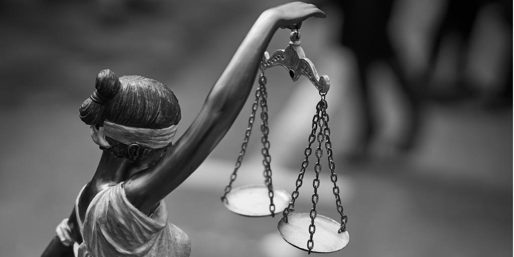 statue of a blindfolded woman holding a balancing scale