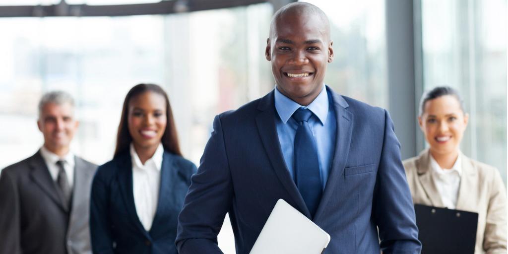 Four individuals in business attire posing for picture 