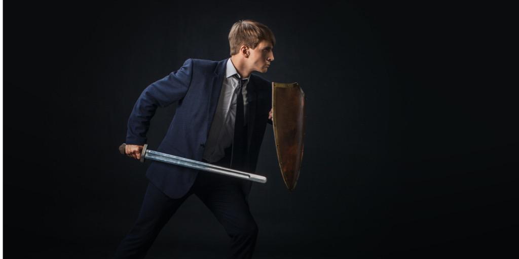 Business man with shield and sword in the fighting