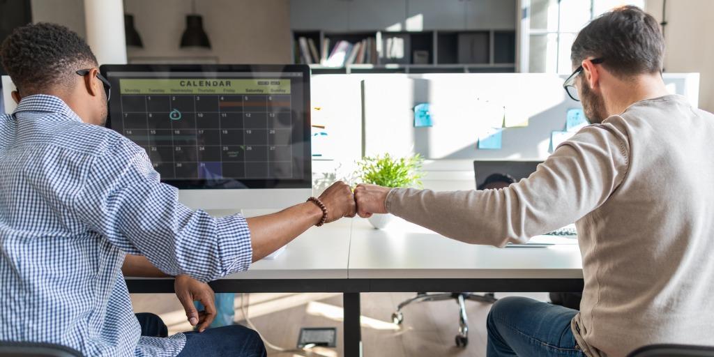 First bump between two colleagues at work in the office