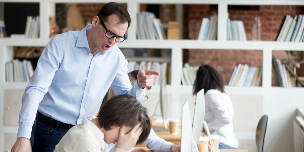 A furious male employee screams at a worker