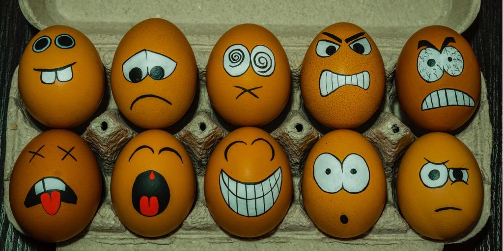 Eggs in the cartons with silly faces painted on them 