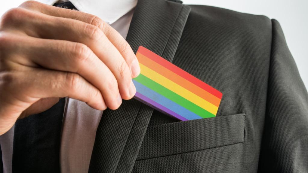 Man putting LGBTQ card in his suit pocket